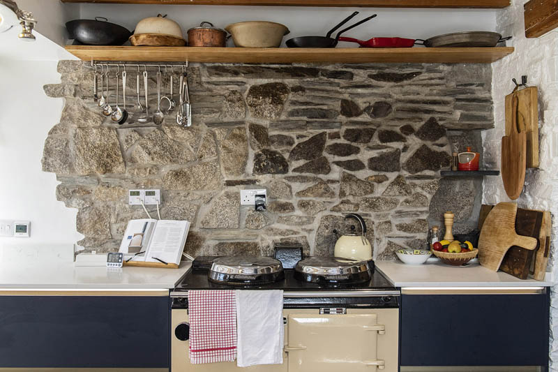 This natural stone wall is used as a splashback in this rustic cottage kitchen