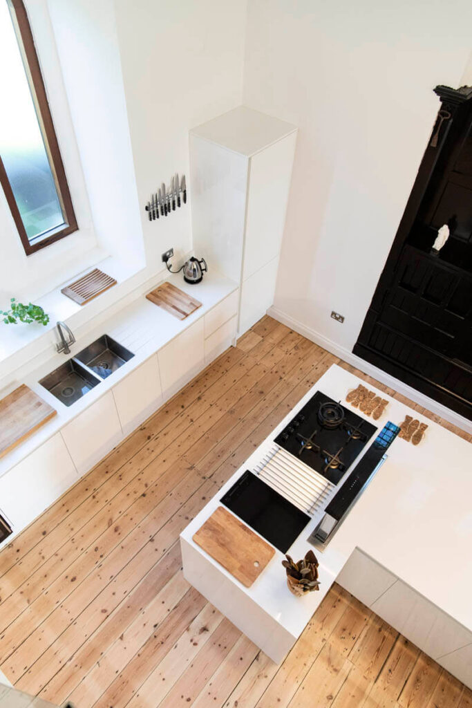 The view of this handleless kitchen from above shows off the lovely wooden flooring