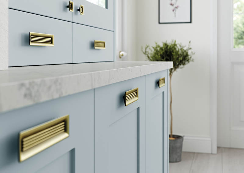 Brass handles matched with light blue cabinets